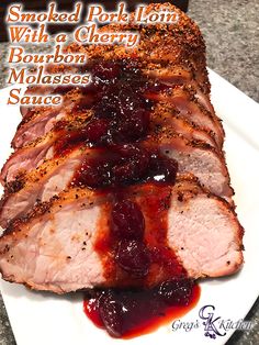 sliced pork loin with cherry bourbon molassses sauce on a white platter