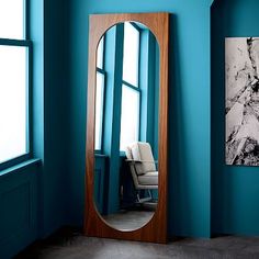 a large mirror sitting next to a blue wall