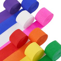 several rolls of toilet paper sitting on top of each other in front of a rainbow colored wall