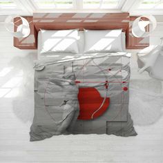 a bed with a red circle on the cover and pillows in front of white brick walls