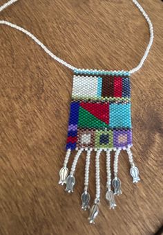 a multicolored beaded necklace on a wooden table