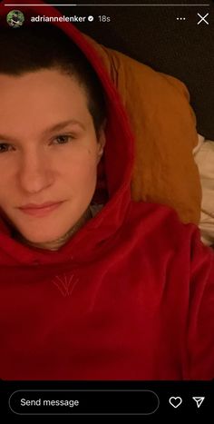 a woman in a red hoodie taking a selfie