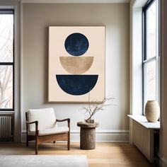 a painting hangs on the wall in a living room with a chair and potted plant