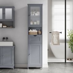 a bathroom with gray cabinets and white fixtures