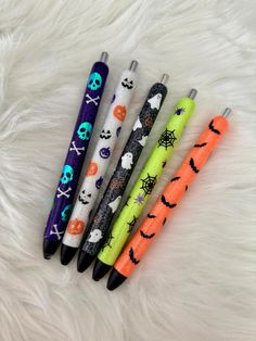 four halloween themed pens sitting on top of a white fur covered floor next to each other