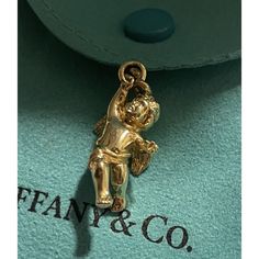 Tiffany & Co. 18k Yellow Gold Cherub Angel Charm Pendant 4 Necklace & Bracelet *Charm Only - Solid Gold 7g Never Worn, Was Cut From The Chain Bracelet, So The Ring Is Open, Any Jeweler Can Solder It Back. In Excellent Condition - Light Hairline Scratches Throughout A Staple Piece For Any Tiffany Lover Or A Great Gift Idea. Metal: 18k Gold Weight: 7 G Pendant: Charm Size Is Approximately 1-1/8” With Bail ( 1” Without The Bail) Hallmarks: T&Co. / 750 Authenticity Guarantee Program Comes With A Pou Luxury Gold Jewelry With Logo Charm, Designer Gold Hallmarked Necklace, Designer 14k Stamped Yellow Gold Jewelry, Designer Yellow Gold Jewelry Stamped 14k, Elegant Gold Plated Jewelry With Logo Charm, Elegant Gold Jewelry With Logo Charm, Formal Yellow Gold Jewelry With Logo Charm, Gold-tone Jewelry With Logo Charm For Formal Occasions, Classic Formal Jewelry With Logo Charm