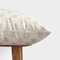 a white pillow sitting on top of a wooden stand