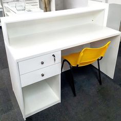 a white desk with two yellow chairs next to it