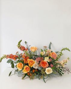 an arrangement of flowers on a white table