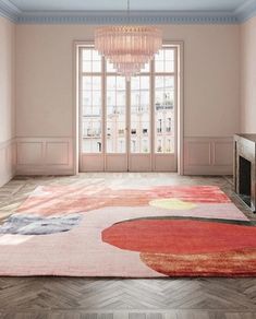 a living room with a chandelier hanging from the ceiling and an area rug on the floor