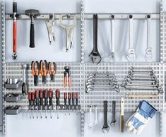 there are many tools hanging on the pegboard in this garage organization system, including wrenches, pliers and screws