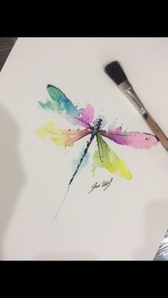 a watercolor painting of a dragonfly with paintbrush on it's side