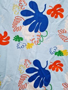 a blue and orange flowered design on a white background with multicolored leaves