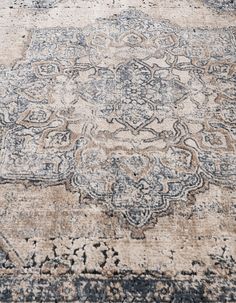 an old rug with faded colors and patterns on the carpet is seen in this close up photo