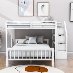 a white bunk bed sitting on top of a hard wood floor next to a rug