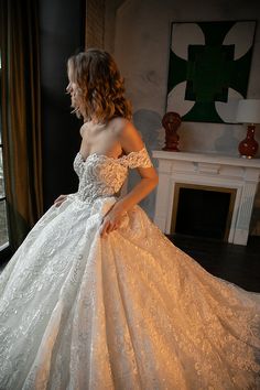 a woman in a wedding dress looking out the window