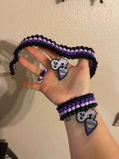 a woman's hand with purple and black beaded bracelets