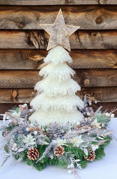 a small white christmas tree with pine cones