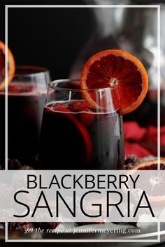 two glasses filled with black berry sanggraa sitting on top of a white plate