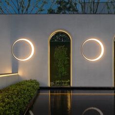 an outdoor area with three circular lights on the wall