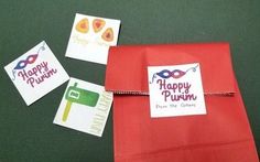 some cards are tied to a red bag with a happy purim message on it