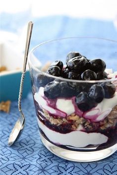 a glass bowl filled with blueberries and yogurt