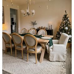 a dining room table with chairs and a christmas tree