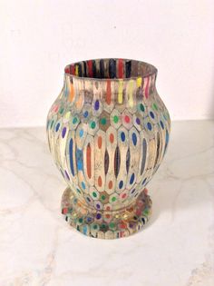 a colorful vase sitting on top of a white counter