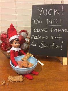 an elf is sitting in front of a bowl of cookies and a sign that says, don't grab the wrong treats