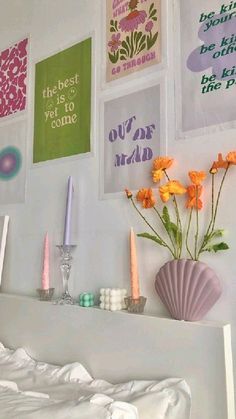 there are many pictures on the wall with flowers in vase and candles next to them