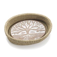 a round tray with a tree design on the front and bottom, in wicker