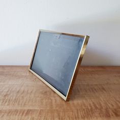 an old photo frame sitting on top of a wooden table