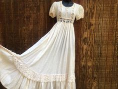 A fun festive boho dress in off white. Cotton material with crochet waistline. Made by Beverly Peige. No size labeled - estimated medium to large - please see measurements. In good vintage condition. MEASUREMENTS (taken with the garment laid flat) Underarm to underarm- 18 inches Waist- 14.5 inches across front Length: 52 inches White Bohemian Maxi Dress With Crochet Trim, Bohemian Cotton Lace Dress With Crochet Trim, Bohemian Cotton Crochet Dress With Lace Trim, Bohemian Crochet Cotton Dress With Lace Trim, White Fitted Maxi Dress With Crochet Trim, Bohemian Spring Maxi Dress With Crochet Lace, Fitted Bohemian Crochet Dress With Lace Trim, Bohemian White Cotton Lace Dress, Bohemian Cotton Maxi Dress With Lace Trim