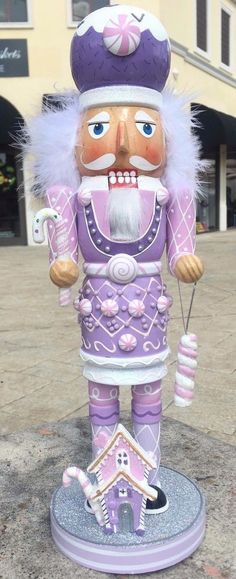 a purple and white nutcracker statue in front of a building