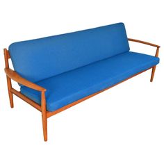 a blue couch sitting on top of a wooden frame