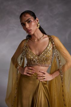 Editor's Note Featuring a ecru olive hand-embellished blouse with wide neckline, solid cape with hand embroidery detailing and asymmetrical drape skirt Color: Olive green Fabric: Heavy satin, organza Fit type: Blouse: fitted Neckline: V-neckline Components: Skirt, cape and blouse Occasion: Haldi mehndi, cocktail and wedding guest Care: Dry Clean Only About the Designer The crux and essence of the label, Divya Aggarwal, is to challenge and revamp the face of ordinary traditional wear while being Cape Organza, Blouse Yoke, Open Blouse, Padded Blouse, Draped Skirt, Embellished Blouse, Desi Wedding, Yellow Blouse, Hem Skirt