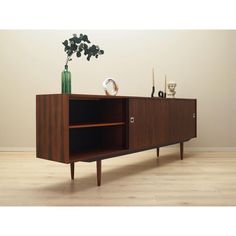 the sideboard is made out of wood and has a plant on top of it