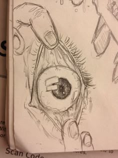 a pencil drawing of an eye being held by someone's hand