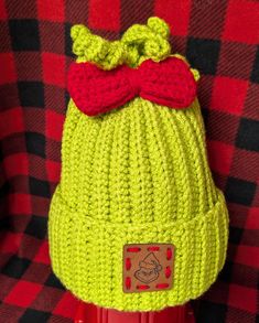 a knitted hat with a red bow on it