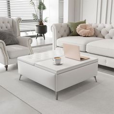 a living room filled with furniture and a laptop computer on top of a coffee table