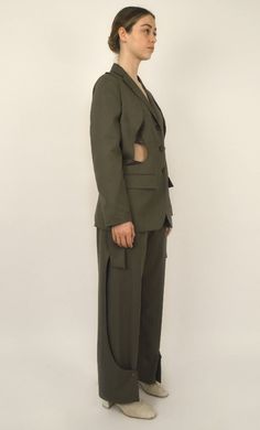 Khaki Tencel Jacket Notched lapel collar Straight cut with a slight adjustment Closure with three buttons on the front Two patch pockets on the sides Two rounded openings on the sides Shoulder panels that go inside the openings Single-breasted Crafted in khaki Tencel, the Kinbaku jacket is the flagship piece of this collection. The two rounded shoulder panels are a distinctive signature of the Louise Marcaud brand. They add a bold and avant-garde touch to the jacket. You can choose to wear it as Khaki Blazer With Lapel Collar And Pockets, Khaki Blazer With Pockets And Lapel Collar, Khaki Single-breasted Utility Jacket With Lapel Collar, Military Style Workwear Blazer With Patch Pockets, Military Style Blazer With Patch Pockets For Work, Utility Khaki Blazer With Pockets, Khaki Blazer With Patch Pockets And Lapel Collar, Military Blazer With Patch Pockets For Work, Khaki Single Breasted Blazer For Office