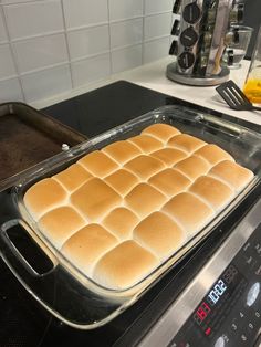 a pan filled with bread sitting on top of a stove next to an electric oven