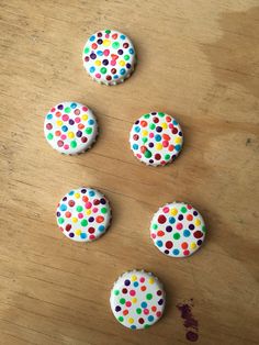 four decorated cookies sitting on top of a wooden table