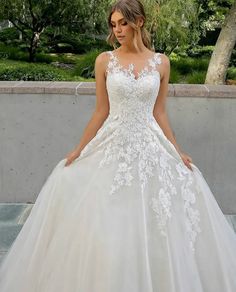 a woman in a white wedding dress posing for the camera with her hands on her hips