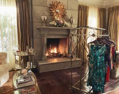 a living room filled with furniture and a fire place next to a window covered in curtains