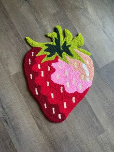 a strawberry rug is on the floor next to a pair of scissors and a pen