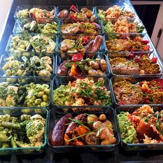 a table topped with lots of trays filled with different types of foods and veggies