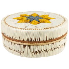 a white box with yellow and blue designs on it's lid, sitting in front of a white background