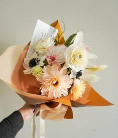 a woman is holding a bouquet of flowers in her left hand and an envelope on the other side