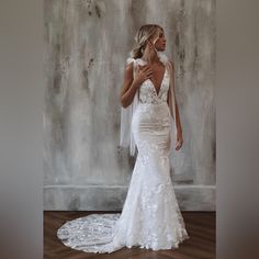 a woman in a white wedding dress posing for the camera with her hands on her chest